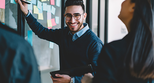 man and woman discussing notes on board